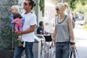 Gwen Stefani grey tank top, baggy jeans, belt, bracelets, ponytail, diaper bag